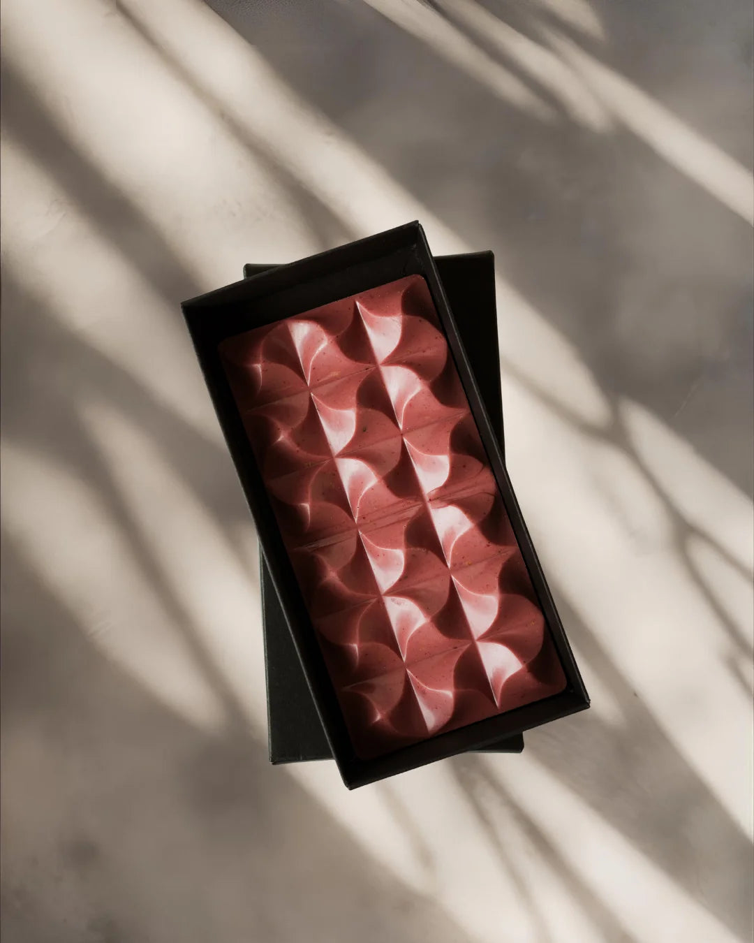 Ruby chocolate block in a black box on a light background